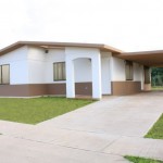 The front view of a white and brown affordable home in Dededo