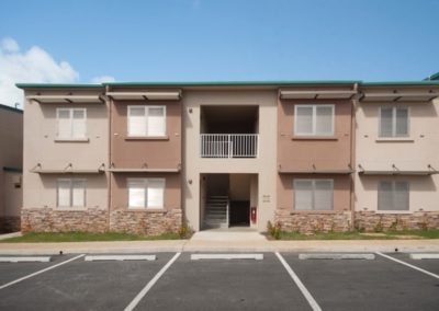 A front view of Ironwood Villas, a modern brown building providing affordable homes in in Mongmong-Toto-Maite